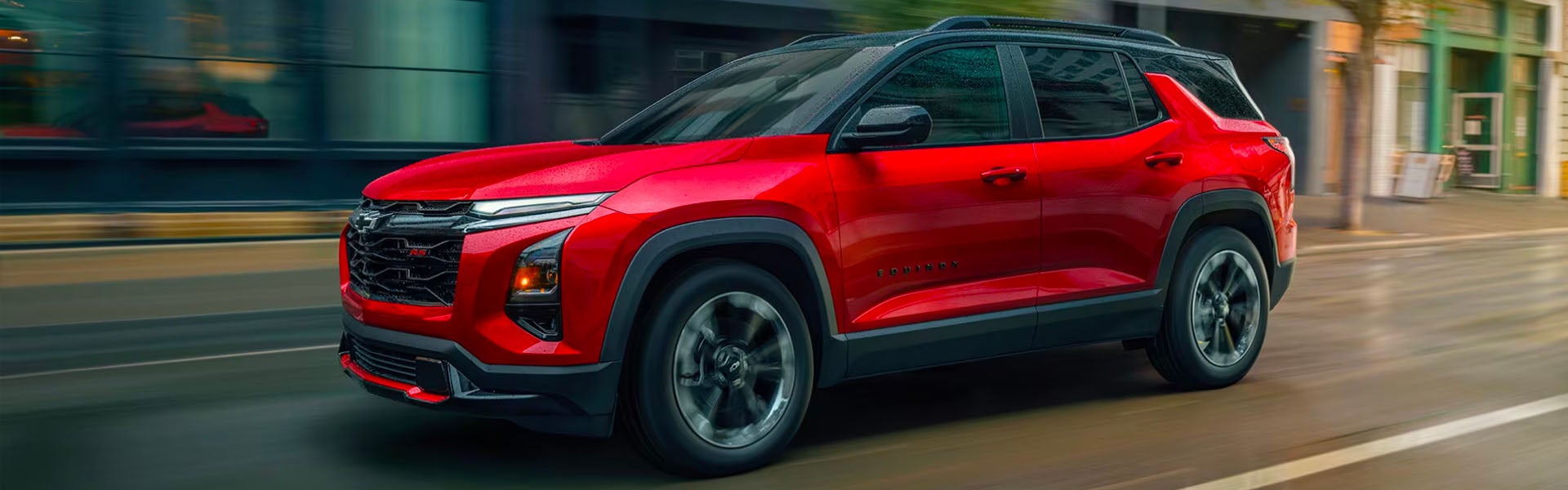 Red 2026 Equinox driving in urban area