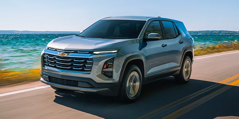 Silver 2026 Chevrolet Equinox driving near water